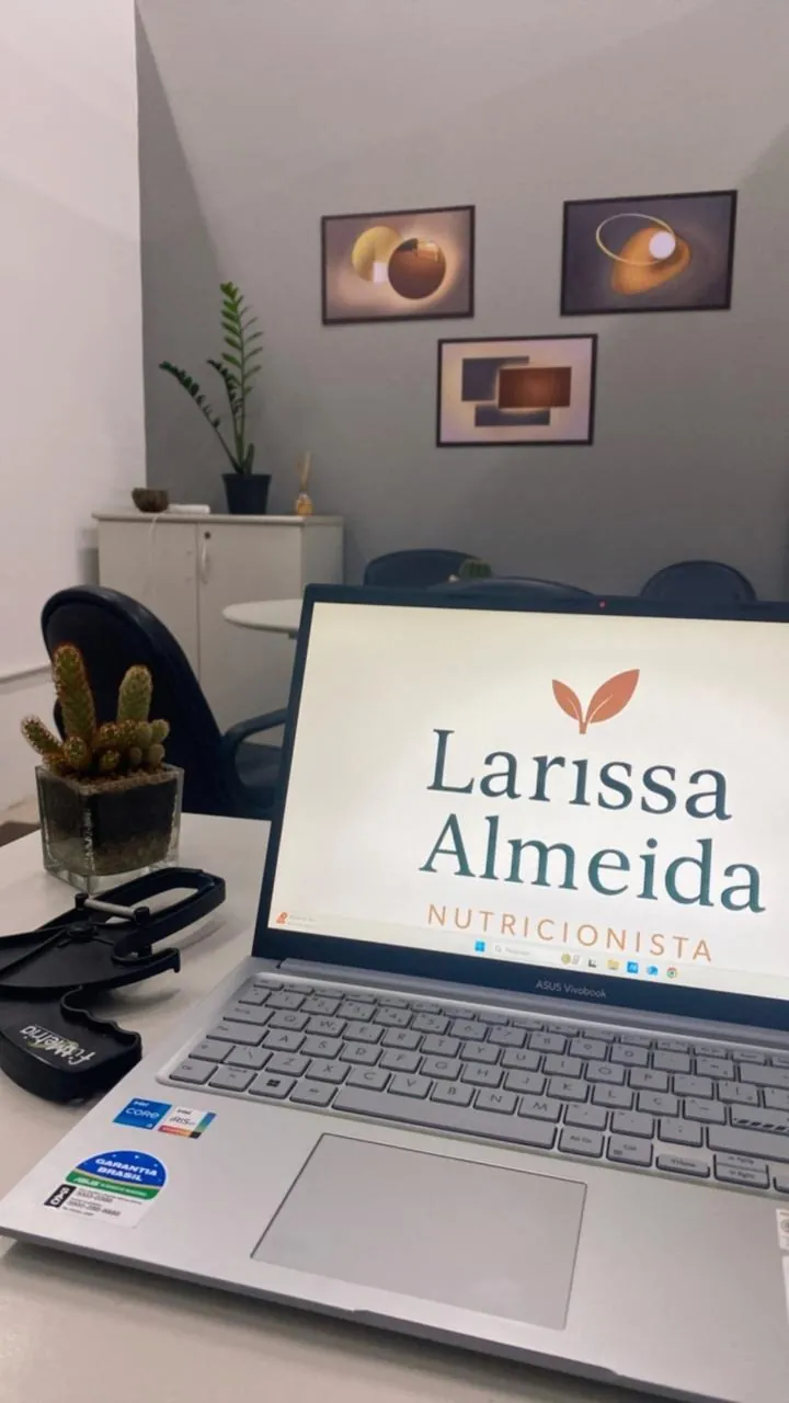 Mesa de atendimento do consultório com o notebook da Larissa Almeida